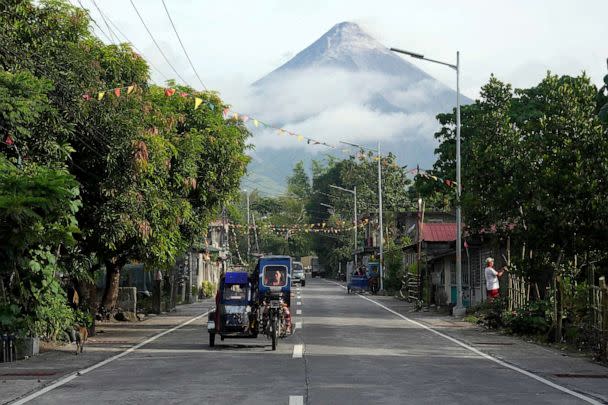 PHOTO: A woman drives a tricycle as Mayon volcano is seen from Legazpi, Albay province, northeastern Philippines, June 13, 2023. (Aaron Favila/AP)