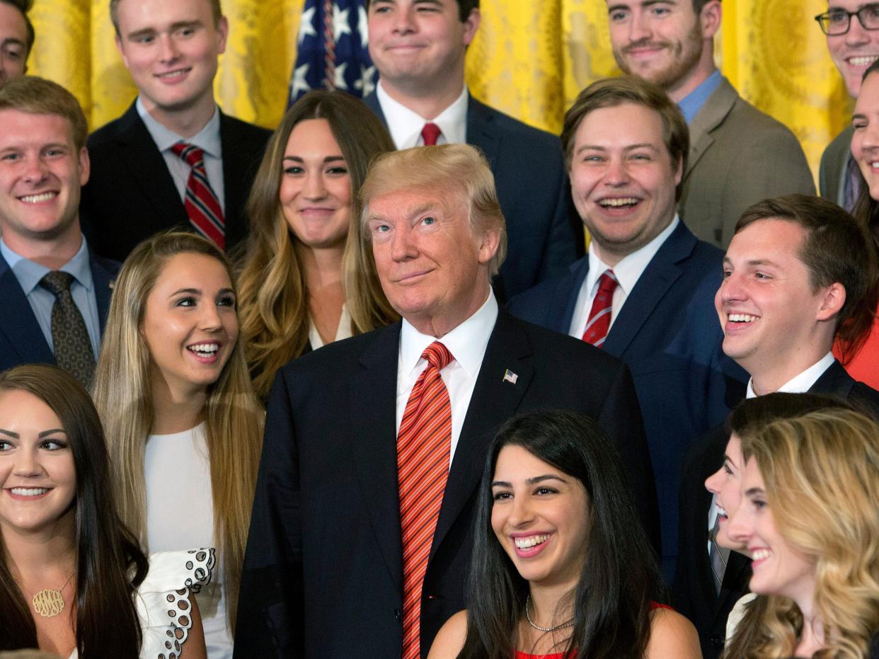 Former President Trump poses for photographs with an outgoing group of interns at The White House on July 24, 2017.