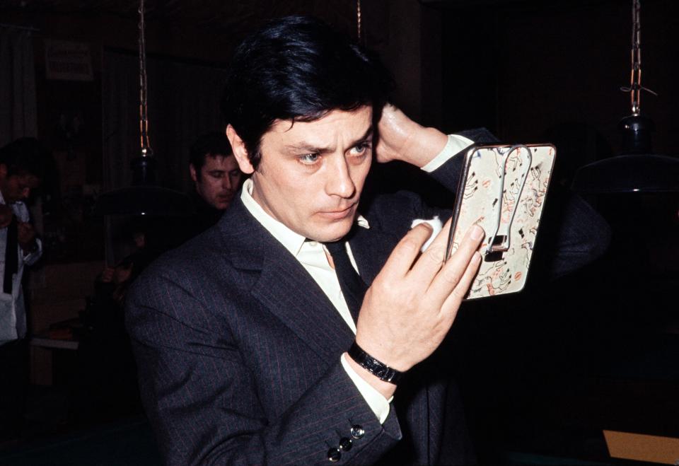 <p>French actor Alain Delon looks at himself in a mirror during the shooting of the film "Le Cercle Rouge" (The Red Circle), directed by Jean-Pierre Melville, on February 22, 1972 in the Boulogne studios. (Photo by AFP) (Photo by -/AFP via Getty Images)</p>
