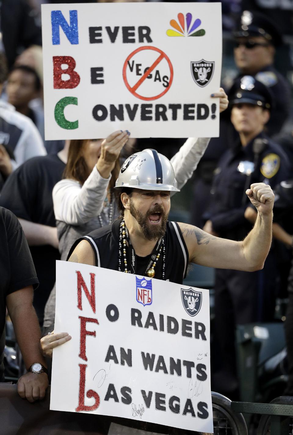 FILE - In this Nov. 6, 2016, file photo, Oakland Raiders fans hold up signs about the team's possible move to Las Vegas during an NFL football game between the Raiders and Denver Broncos in Oakland, Calif. The Oakland Raiders have filed paperwork to move to Las Vegas. Clark County Commission Chairman Steve Sisolak told The Associated Press on Thursday, Jan. 19, 2017, that he spoke with the Raiders. (AP Photo/Marcio Jose Sanchez, File)