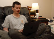 Graham Berryman looks at his laptop at his apartment in Springfield, Mo., on Thursday, Oct. 21, 2021. Berryman is a lawyer that his struggled to find work during the pandemic after he was let go by his previous firm in August 2020. He has lived off savings since losing his job, but the money may not last much longer. (AP Photo/Bruce E. Stidham)