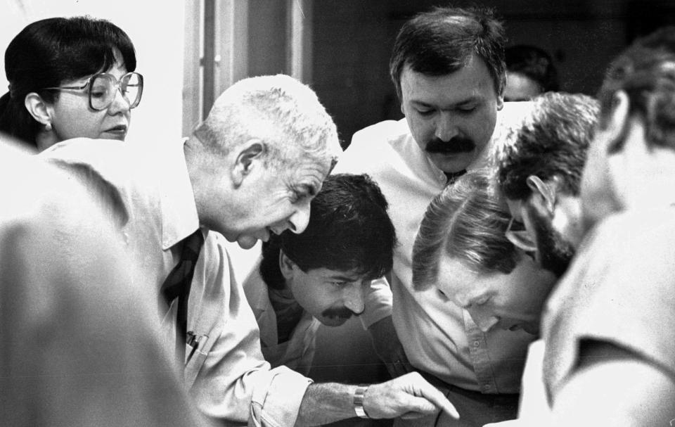 Conferring over a body that was brought to the morgue overnight, Dr. Werner Spitz and staff decide what examination procedures, such as X-ray or autopsy will be needed in 1988.