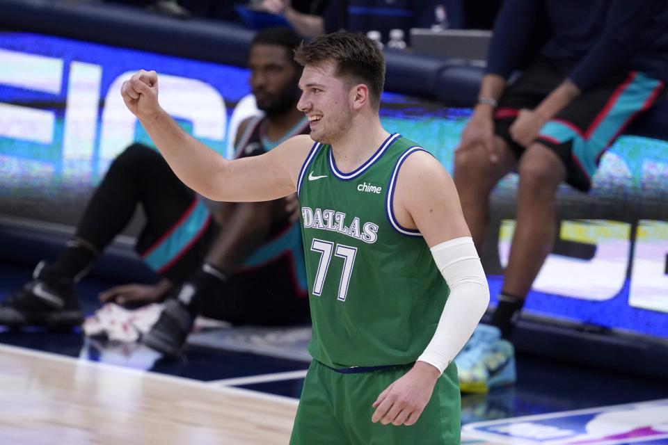 Dallas Mavericks' Luka Doncic (77) celebrates a basket scored by Dorian Finney-Smith in the second half of an NBA basketball game against the Memphis Grizzlies in Dallas, Monday, Feb. 22, 2021. (AP Photo/Tony Gutierrez)