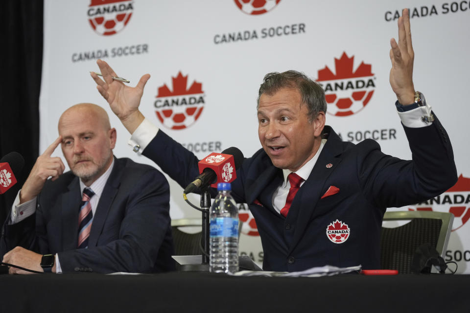 Canada Soccer president Nick Bontis, right, speaks as interim general secretary Earl Cochrane listens during a news conference in Vancouver, British Columbia, Sunday, June 5, 2022. After refusing to train on Friday and Saturday, Canada's men's soccer team said it refused to play its World Cup warmup match against Panama, Sunday because of a labor dispute with Soccer Canada. (Darryl Dyck/The Canadian Press via AP)