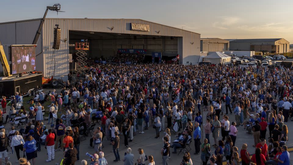 People listen to Harris speak at Detroit Metropolitan Wayne County Airport on August 7, 2024, in Romulus, Michigan, where screens were set up for those who couldn't see the stage. - Julia Nikhinson/AP