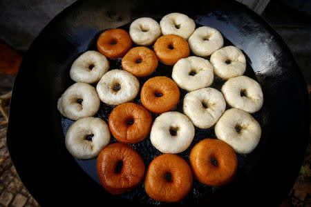 A vendor cooks doughnuts for breakfast within the walled city of Harar, Ethiopia, February 24, 2017. REUTERS/Tiksa Negeri