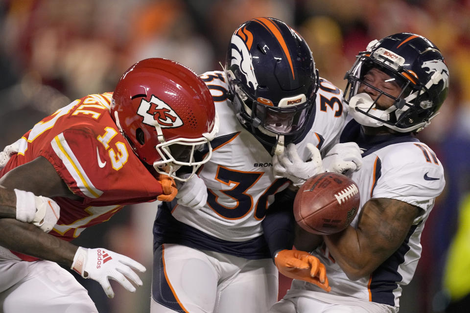 Denver Broncos' Diontae Spencer (11) fumbles a punt return as he is hit by teammate Caden Sterns (30) and Kansas City Chiefs' Byron Pringle (13) watches during the second half of an NFL football game Sunday, Dec. 5, 2021, in Kansas City, Mo. Pringle recovered the fumble. (AP Photo/Charlie Riedel)