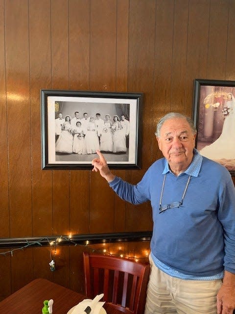 "Big Joe" Minuti, the grandson of Mrs. Robino, points to his wedding photo hanging on the wall of the restaurant his grandmother started.