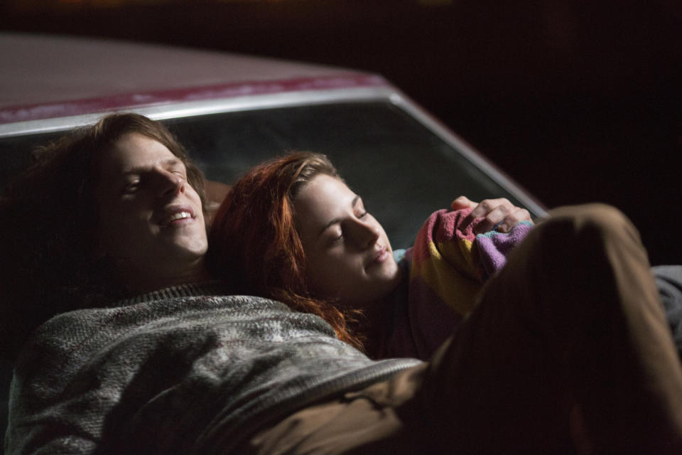 Jesse Eisenberg and Kristen Stewart laying on the hood of a car together in American Ultra