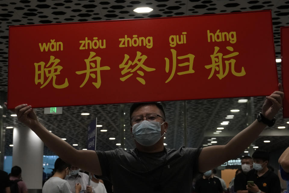 A supporter of Huawei CFO Meng Wanzhou holds up a sign that reads "Wan Zhou Finally Returns "at the Shenzhen Bao'an International Airport in Shenzhen in southern China's Guangdong Province, Saturday, Sept. 25, 2021. A top executive from global communications giant Huawei Technologies returned to China on Saturday following what amounted to a high-stakes prisoner swap with Canada and the U.S. (AP Photo/Ng Han Guan)