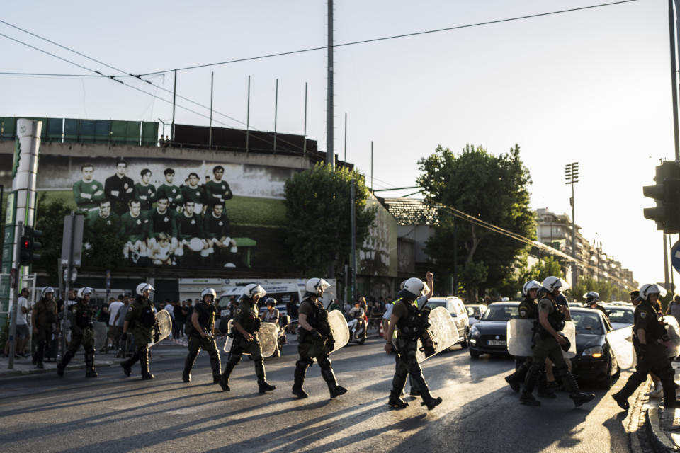 Riot Police cross the street outside the Leoforos stadium in Athens , on Wednesday, Aug. 9, 2023. Athens Panathinaikos faced Marseille Wednesday in a Champions League qualifier, which went ahead under strict security measures at Leoforos Stadium in the center of the Greek capital. In clashes late Monday in Athens, a 29-year-old Greek fan was stabbed to death outside AEK Athens' stadium, prompting the cancellation of a Champions League qualifier against Dinamo Zagreb. (AP Photo/Petros Giannakouris)