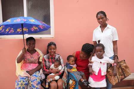 Mothers wait with their children outside the Neurosurgical and Hydrocephalus Treatment Center in Luanda, Angola, September 6, 2018. Picture taken September 6, 2018. REUTERS/Stephen Eisenhammer