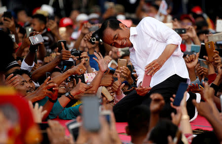 Indonesia's presidential candidate for the upcoming general election Joko Widodo takes pictures with his supporters during his first campaign rally at a stadium in Serang, Banten province, Indonesia, March 24, 2019. REUTERS/Willy Kurniawan/Files