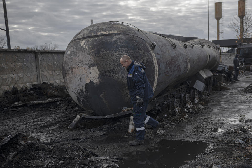 A worker walks at a fuel depot hit by Russian missile in the town of Kalynivka, about 30 kilometers (18 miles) southwest of Kyiv, Ukraine, Thursday, Oct. 27, 2022. Environmental damage caused by Ukraine's war is mounting in the 8-month-old conflict, and experts warn of long-term health consequences for the population. (AP Photo/Andrew Kravchenko)