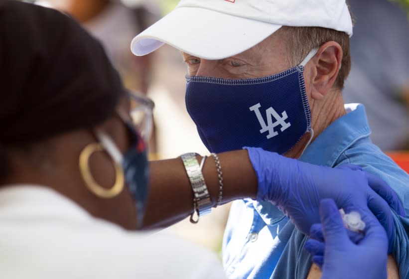 SAN FERNANDO , CA - OCTOBER 16: Licensed Vocational Nurse Theresa Jackson, left, gives a flu shot to Los Angeles Unified School District Superintendent Austin Beutner, right, at San Fernando Middle School. L.A. Unified is offering free flu shots to students and their families through Health Net to forestall a twindemic of COVID-19 combined with flu season on Friday, Oct. 16, 2020 in San Fernando , CA. (Francine Orr / Los Angeles Times)