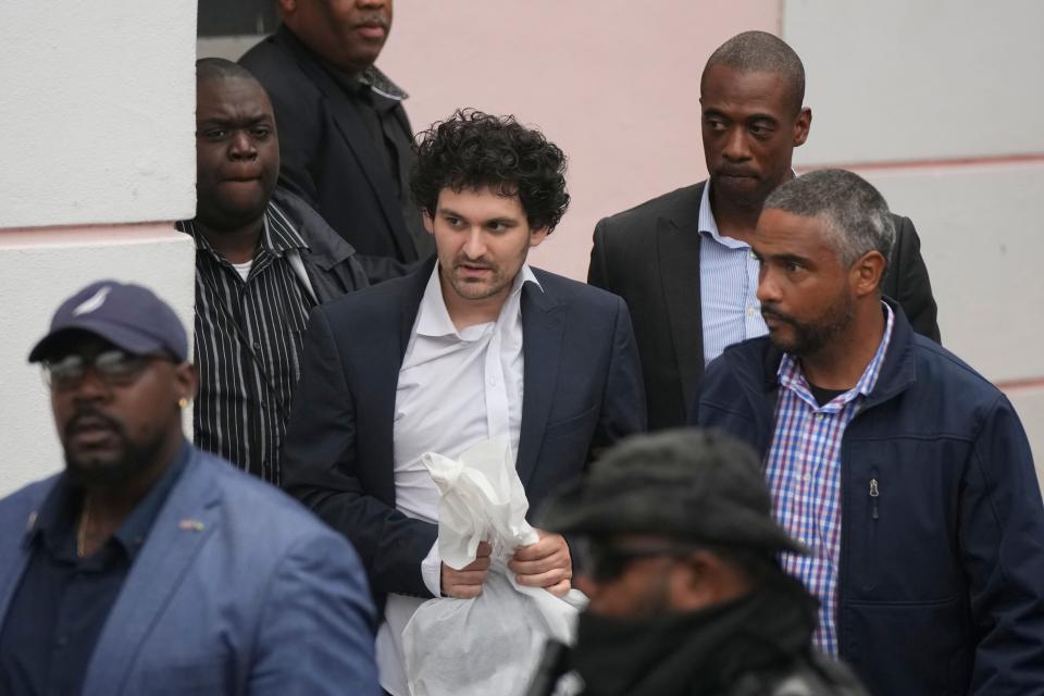 FTX founder Sam Bankman-Fried, center, is escorted from court in Nassau, Bahamas, on Dec. 21, 2022, after agreeing to be extradited to the United States.