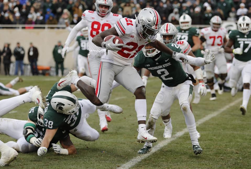 Ohio State wide receiver Parris Campbell (21) leaps over Michigan State linebacker Byron Bullough (38) to score on a 1-yard run during the first half of an NCAA college football game, Saturday, Nov. 10, 2018, in East Lansing, Mich. (AP Photo/Carlos Osorio)