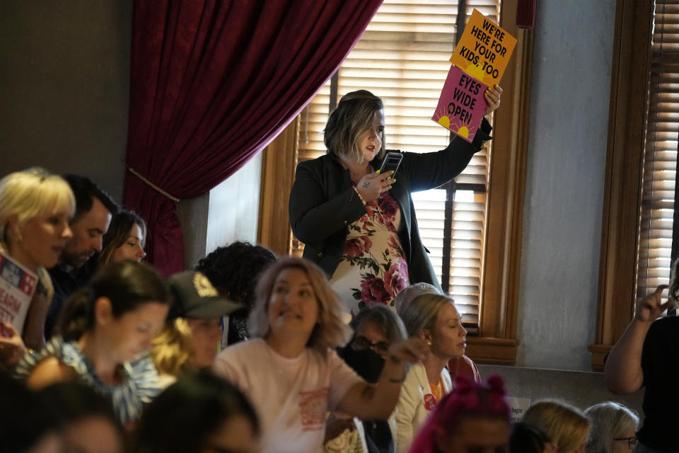 Brittany Cyr holds signs in the House gallery supporting gun law reform during a special session of the state legislature on public safety Monday, Aug. 28, 2023, in Nashville, Tenn. (AP Photo/George Walker IV)