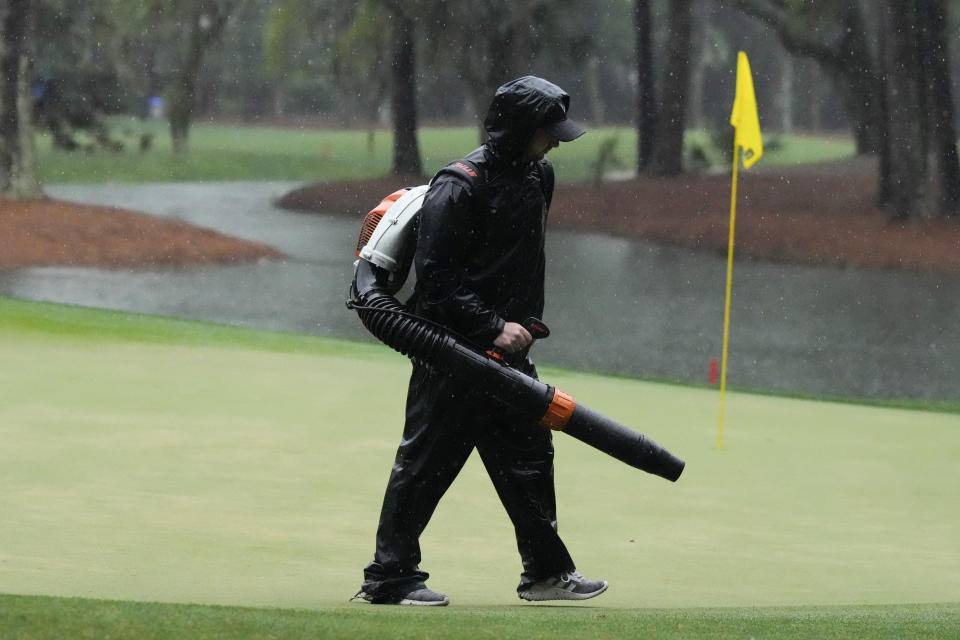 A course worker cleans the green on the 15th hole during a weather delay in the final round of the RBC Heritage golf tournament, Sunday, April 21, 2024, in Hilton Head Island, S.C. (AP Photo/Chris Carlson)