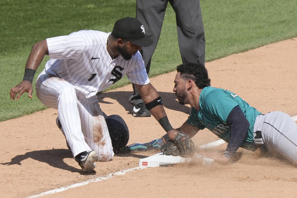 Seattle Mariners' Jose Caballero steals third as Chicago White Sox third baseman Elvis Andrus applies a late tag during the seventh inning of a baseball game Wednesday, Aug. 23, 2023, in Chicago. (AP Photo/Charles Rex Arbogast)