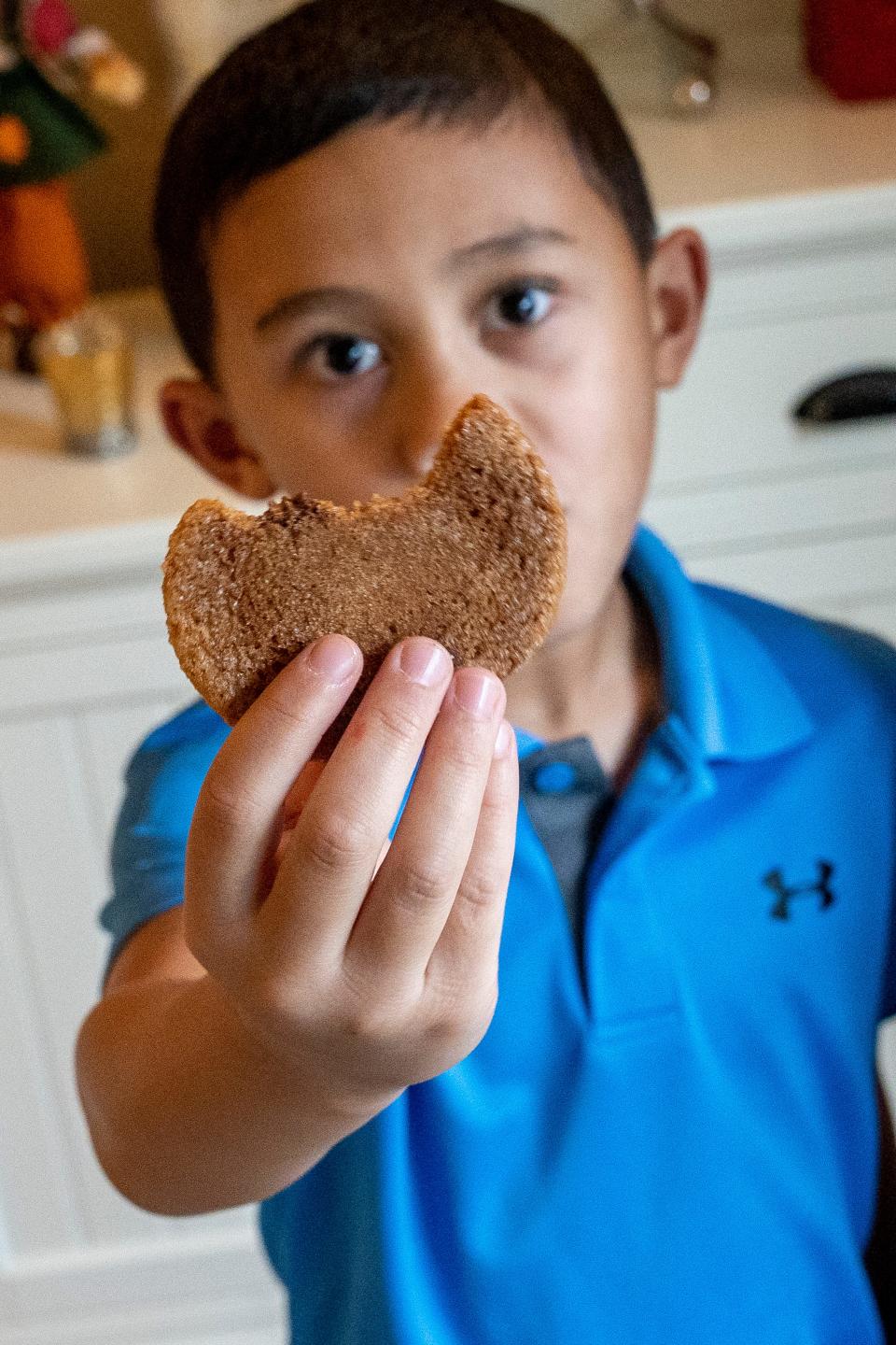 Carson Castro shows his partially eaten cookie at his Ordadell home on Thursday, September 28, 2023. The Castro family started a business, Carson's Cookie Dough, to offer jobs to differently abled people. Carson is the youngest Castro, has autism and is the motivation behind starting the company.