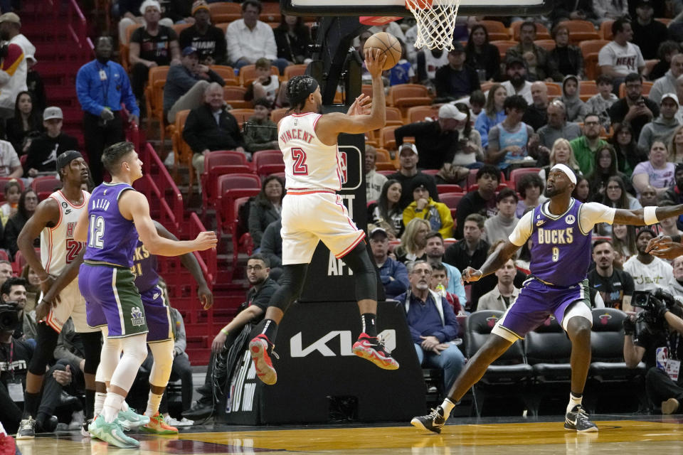 Miami Heat guard Gabe Vincent (2) goes to the basket as Milwaukee Bucks guard Grayson Allen (12) and forward Bobby Portis (9) defend during the first half of an NBA basketball game, Saturday, Jan. 14, 2023, in Miami. (AP Photo/Lynne Sladky)