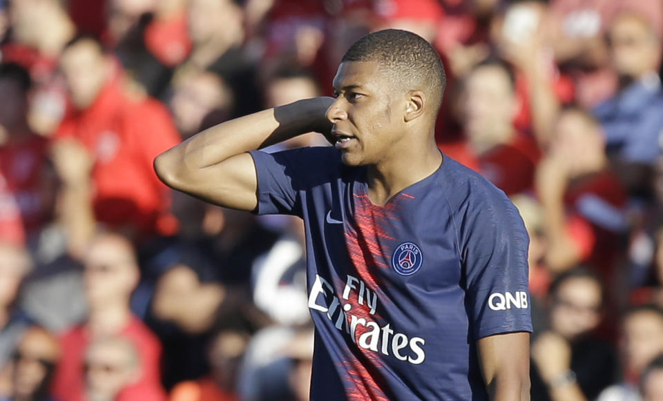 PSG's Kylian Mbappe reacts as he walks out to the pitch received the red cart during their League One soccer match between Nimes and Paris Saint-Germain at Jean-Bouin stadium in Nimes, southern France, Saturday Sept. 1, 2018. (AP Photo/Claude Paris)