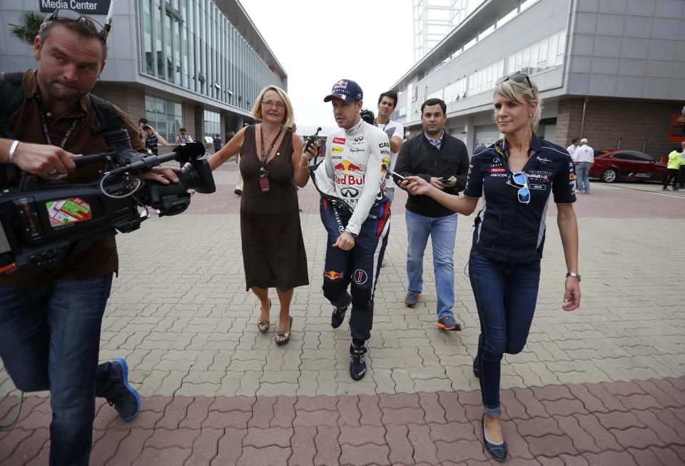 Red Bull Formula One driver Sebastian Vettel of Germany (center R) is being interviewed on the run after the qualifying session for the Korean F1 Grand Prix at the Korea International Circuit in Yeongam, October 5, 2013. REUTERS/Kim Hong-Ji (SOUTH KOREA - Tags: SPORT MOTORSPORT F1)