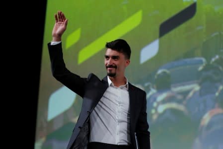 Cyclist Julian Alaphilippe waves on stage during a news conference to unveil the itinerary of the 2020 Tour de France cycling race in Paris