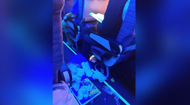 The photo shows litter strewn across the plane's aisle, believed to be from one passenger. Source: Reddit