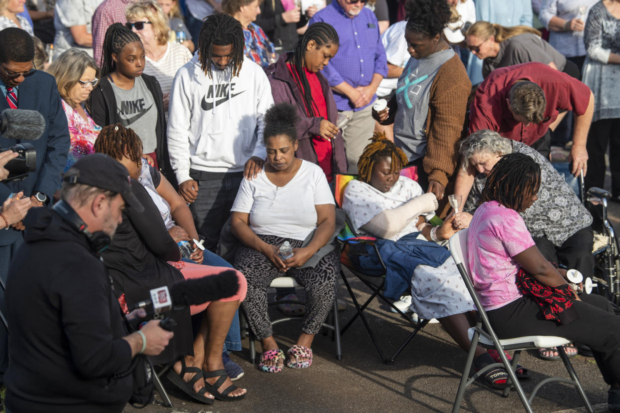 Shooting victim Taniya Cox, wearing a cast, prays with her family during a vigil at First Baptist Church in Dadeville, Ala., on Sunday, April 16, 2023.  (Jake Crandall / The Advertiser / USA Today Network)