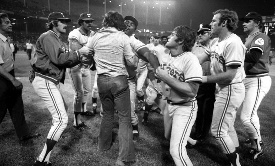 CLEVELAND, OH – JUNE 4,1974: Members of the Texas Rangers restrain a fan from running onto the field during a game against the Cleveland Indians on June 4, 1974 at Cleveland Municipal Stadium in Cleveland, Ohio. Texas was awarded a win by forfeit 5-5 when the game was called by the umpires, due to fans storming the field during 10 cent beer night. (Photo by: Paul Tepley Collection/Diamond Images/Getty Images)