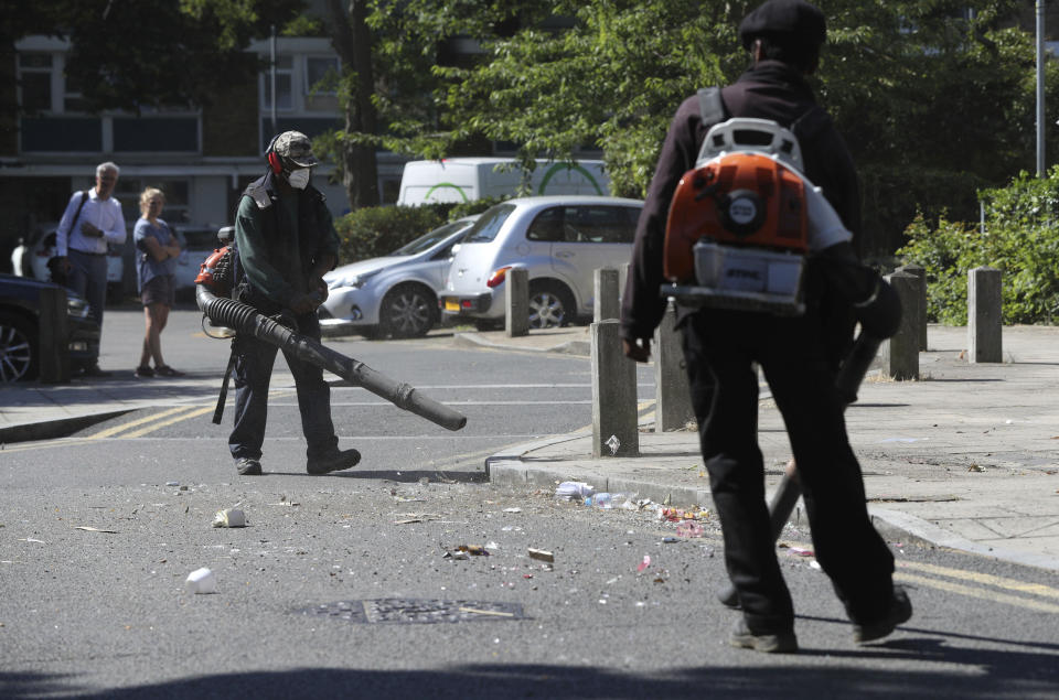 Volunteers clean up following violent confrontations with police took place overnight, in the Brixton area of London, Thursday June 25, 2020. Authorities have reported fifteen officers were injured and four people were arrested following the incident. (Jonathan Brady/PA via AP)