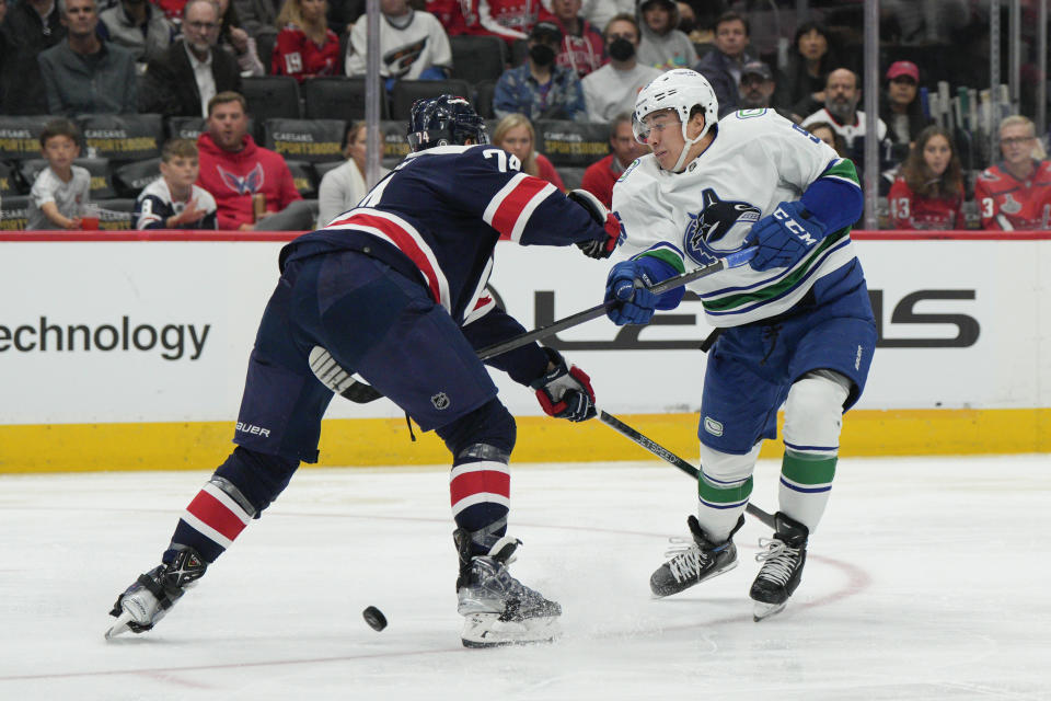 Vancouver Canucks left wing Andrei Kuzmenko (96) tries to push the puck past Washington Capitals defenseman John Carlson (74) during the second period of an NHL hockey game, Monday, Oct. 17, 2022, in Washington. (AP Photo/Jess Rapfogel)