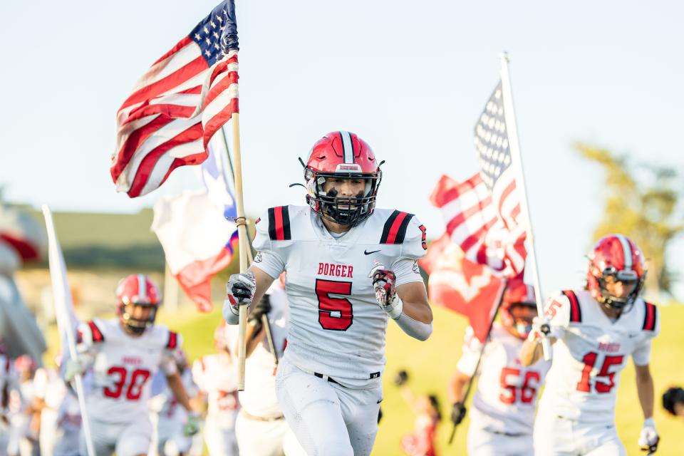 Borger Bulldogs’s Dylan McWhorter carries the US flag onto the field before a game against the Palo Duro Dons on Thursday, September 16, 2021 at Dick Bivins Stadium in Amarillo, TX.