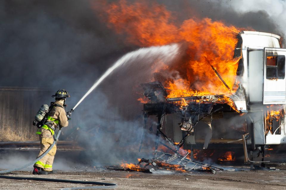 A Topeka Fire Department firefighter works to extinguish a camper that was ablaze on Dec. 27, 2022. The department currently has 16 vacancies.