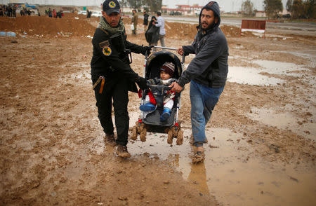 Displaced Iraqis flee their homes on a rainy day as Iraqi forces battle with Islamic State militants, in western Mosul, Iraq March 13, 2017. REUTERS/Suhaib Salem