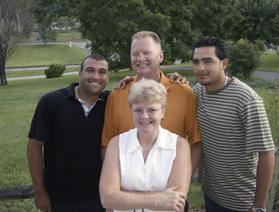 In this photo provided by TeriAnn Reynolds, minor league baseball player hosts Linda, front and Ricky York, center rear, pose with players Andres Rosales, left, and Carlos Elias González outside the York residence in Johnson City, Tenn., in July 2008. (Photo courtesy TeriAnn Reynolds via AP)