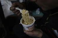 A man eats instant noodles at Friendly House which opened as an emergency warming shelter on Saturday, Jan. 13, 2024, in Portland, Ore. (AP Photo/Jenny Kane)