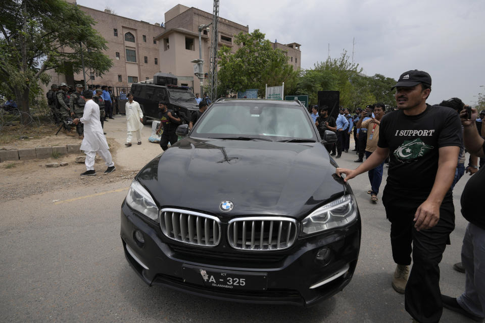 Security personnels clear way for a vehicle carrying the Pakistan's former Prime Minister Imran Khan arrives to appear in a court, in Islamabad, Pakistan, Tuesday, May 23, 2023. Khan on Tuesday pressed his legal battle before a court in the capital, Islamabad, which granted him protection from arrest until early next month in several cases where he faces terrorism charges for inciting violence. (AP Photo/Anjum Naveed)