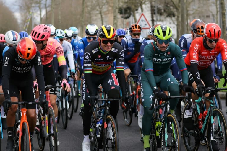 Le Belge Remco Evenepoel de la Soudal Quick–Step (casque jaune et noir) et le Slovène Primoz Roglic (en vert) de la BORA–Hansgrohe prennent le départ de la première étape de Paris-Nice le 3 mars 2024 aux Mureaux en région parisienne (Thomas SAMSON)