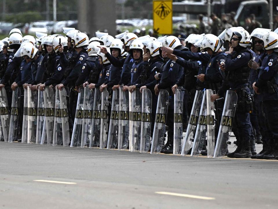 Police forces stand guard as soldiers dismantle a camp by Bolsonaro backers (AFP/Getty)