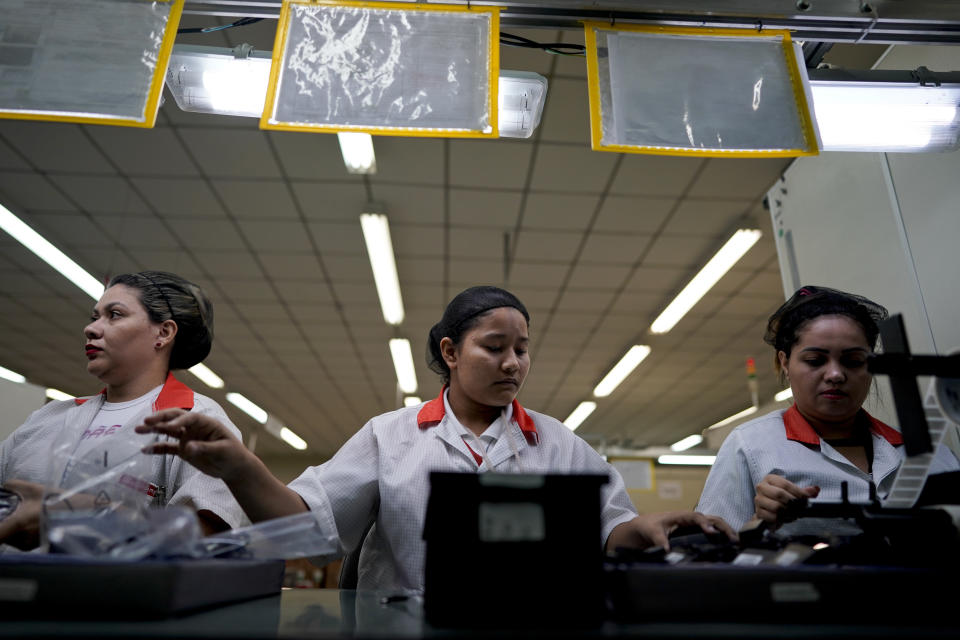 Landineia Silva (centra) ensambla baterías de celulares en la fábrica Salcomp en Manaos, Brasil, el jueves 16 de febrero de 2019. (AP Foto/Víctor R. Caivano)