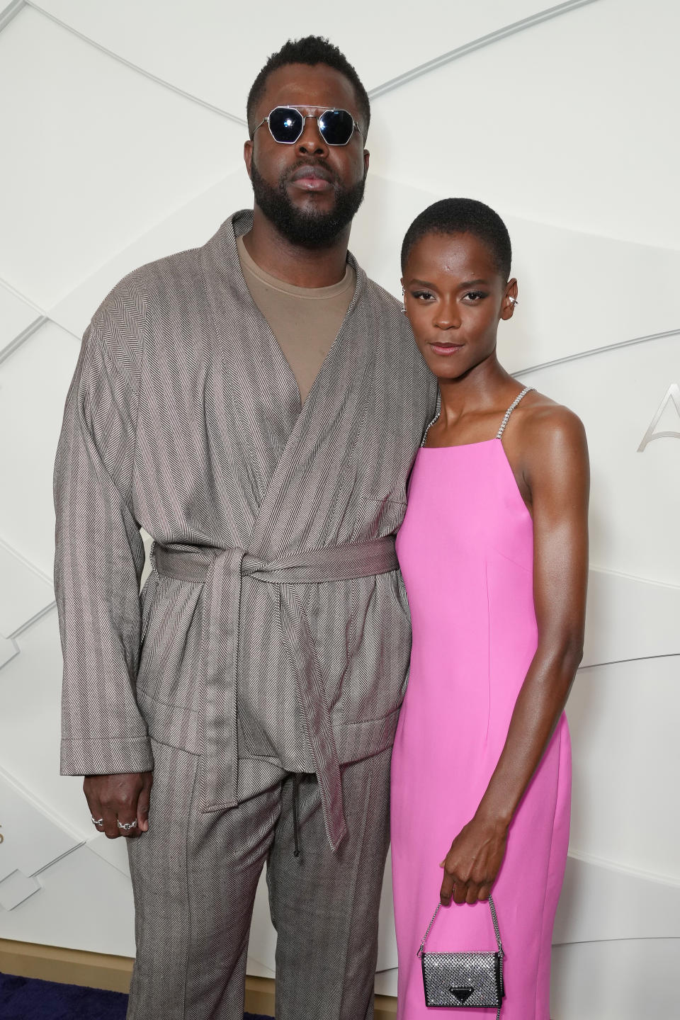 Winston en tenue grise et Leticia en robe rose sur le tapis rouge