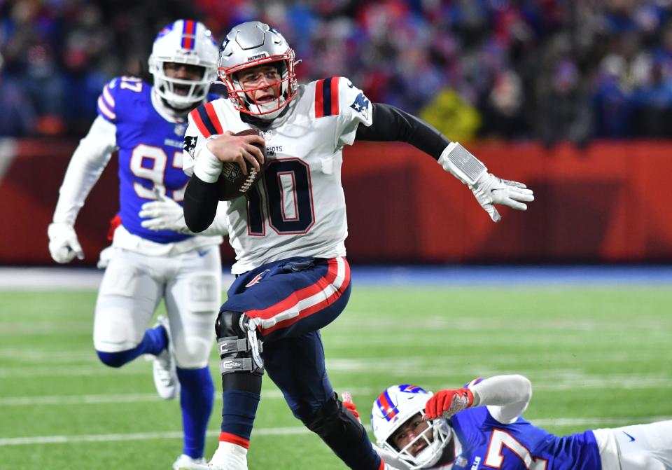 Patriots quarterback Mac Jones (10) scrambles during the first quarter of the AFC Wild Card playoff game against the Buffalo Bills at Highmark Stadium.