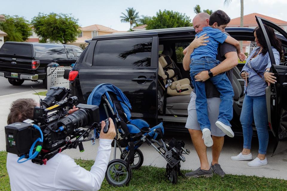 Chris Kopchak carries Liam Cruz from the family van during filming for a special episode of Designing Spaces. Liam's family was one of 10 featured in the Palm Beach Post Season to Share drive to help our neighbors in late 2022 and early 2023.