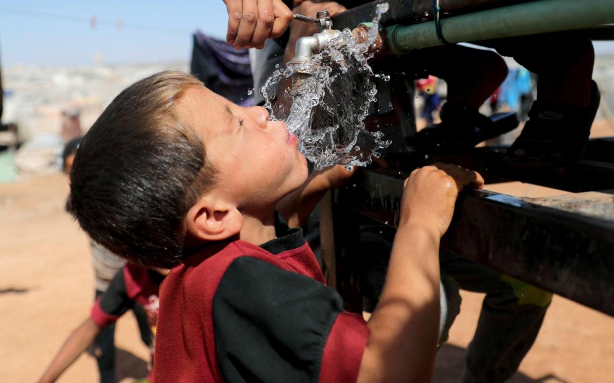 A boy drinks water, at Atmeh camp, near the Turkish border, Syria -  KHALIL ASHAWI / Rueters