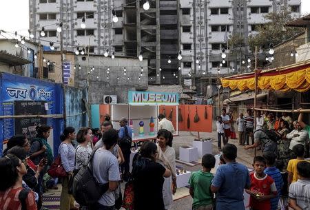 Members of the media and residents gather around a mobile museum displayed on an improvised handcart in Dharavi, one of Asia's largest slums, Mumbai, February 18, 2016. REUTERS/Danish Siddiqui