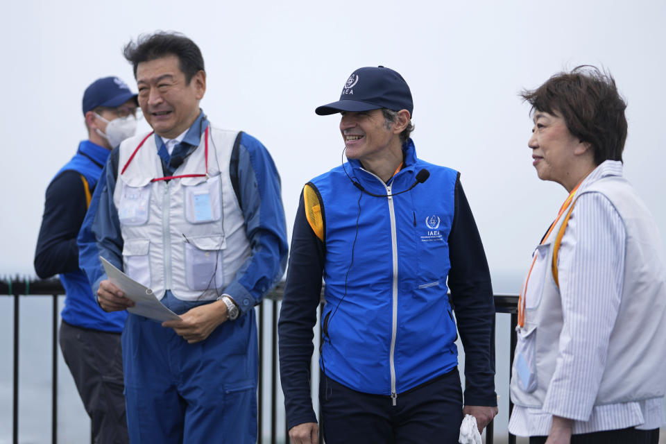 Tomoaki Kobayakawa, President of Tokyo Electric Power Co., left, and Japanese Vice Industry Minister Fusae Ota escort Rafael Mariano Grossi, Director General of the International Atomic Energy Agency, back to their bus while visiting the damaged Fukushima nuclear power plant in Futaba, northeastern Japan, Wednesday, July 5, 2023. (AP Photo/Hiro Komae, Pool)