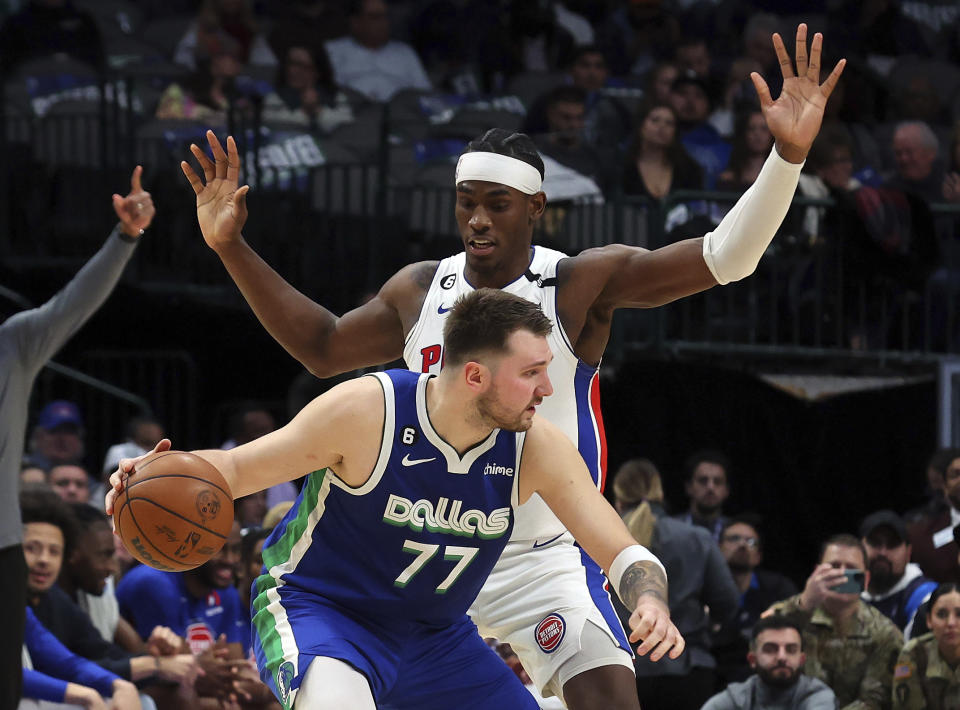 Dallas Mavericks guard Luka Doncic (77) is guarded by Detroit Pistons center Jalen Duren, top, in the first half of an NBA basketball game Monday, Jan. 30, 2023, in Dallas. (AP Photo/Richard W. Rodriguez)